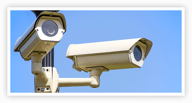 Two cameras are mounted on a pole to look like they 're looking at something.