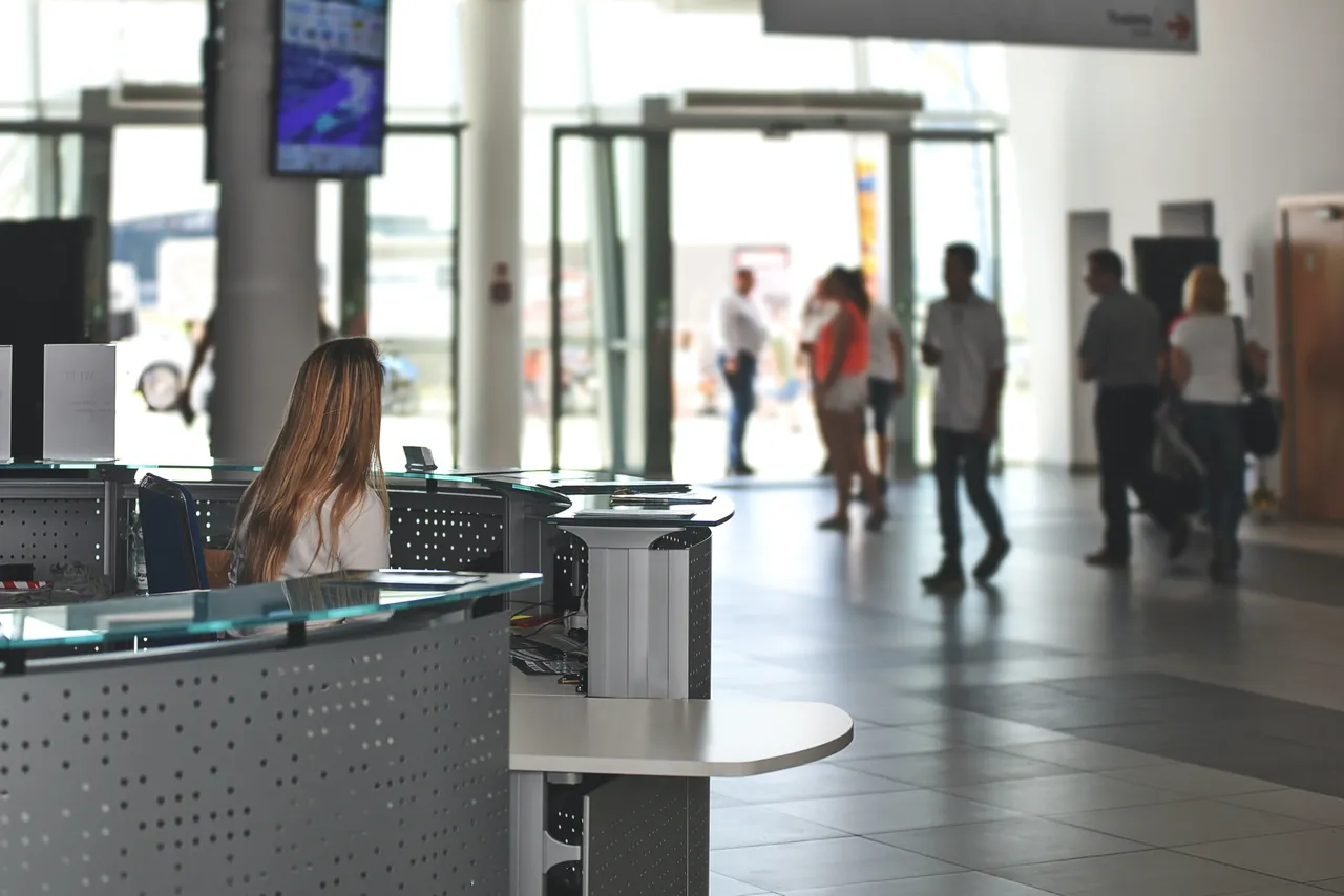 A woman sitting at the front desk of an airport.