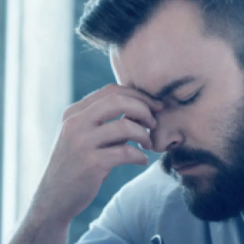 A man with his hand to the side of his face.